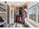 Bright walk-in closet with custom shelving and a bench seat under a window that provides lots of natural light at 14953 Akron Ct, Brighton, CO 80602