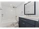 An updated bathroom with tile surround bathtub, a vanity with modern fixtures and tiled floors at 580 Vance St # A, Lakewood, CO 80226