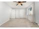 A bedroom with light colored floors, modern fan, three closets, and a bright window at 580 Vance St # A, Lakewood, CO 80226