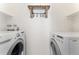A laundry room with a shelf, hanging hooks and two modern washing machines at 580 Vance St # A, Lakewood, CO 80226