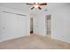 Bedroom offers neutral carpet, ceiling fan, an exterior view, and en suite bath at 4802 E Kentucky Ave # E, Denver, CO 80246