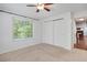 Bright bedroom with neutral carpet, a ceiling fan, and a large window for natural light at 4802 E Kentucky Ave # E, Denver, CO 80246