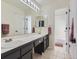 Well-lit bathroom with double sinks, dark cabinetry, and a separate tub at 10141 Brady Pl, Highlands Ranch, CO 80130