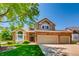 Brick two-story house with a three-car garage and manicured lawn at 10141 Brady Pl, Highlands Ranch, CO 80130