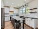 Modern kitchen with white cabinets, quartz countertops, and a large island at 10141 Brady Pl, Highlands Ranch, CO 80130