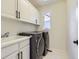 Laundry room with washer, dryer, cabinets, and utility sink at 10141 Brady Pl, Highlands Ranch, CO 80130