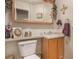 Cozy half bathroom with framed mirror, toilet, and vanity sink at 3300 W Florida Ave # 51, Denver, CO 80219