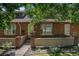 Charming brick townhome featuring a bay window, neat landscaping, and a welcoming front entrance at 3300 W Florida Ave # 51, Denver, CO 80219