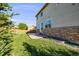 Beautiful backyard showcases a lush lawn, concrete patio, and stone foundation at 19294 E Warren Pl, Aurora, CO 80013
