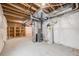 Unfinished basement with exposed wood beams, plastic-covered walls, and a concrete floor at 19294 E Warren Pl, Aurora, CO 80013