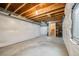 Unfinished basement with exposed wood beams, plastic-covered walls, and a concrete floor at 19294 E Warren Pl, Aurora, CO 80013