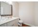 Cozy half bath featuring a modern vanity with sink and a decorative mirror at 19294 E Warren Pl, Aurora, CO 80013