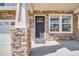Inviting front porch with stone detailing, white columns, and a view of the home's entrance at 19294 E Warren Pl, Aurora, CO 80013