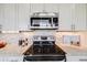 Close-up of a kitchen with stainless steel appliances, light backsplash, and granite countertops at 19294 E Warren Pl, Aurora, CO 80013