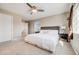 Main bedroom features a large bed, a ceiling fan, two windows, and carpeted floors at 19294 E Warren Pl, Aurora, CO 80013