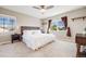 Main bedroom features a large bed, a ceiling fan, two windows, and carpeted floors at 19294 E Warren Pl, Aurora, CO 80013