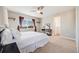 Main bedroom features a large bed, a ceiling fan, two windows, and carpeted floors at 19294 E Warren Pl, Aurora, CO 80013