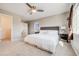 Main bedroom features a large bed, a ceiling fan, two windows, and carpeted floors at 19294 E Warren Pl, Aurora, CO 80013