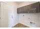 Practical mudroom includes overhead storage and hookups for a washer and dryer at 19294 E Warren Pl, Aurora, CO 80013