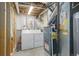 Unfinished basement laundry with washer, dryer, utilities and exposed pipes and beams at 20626 Willowbend Ln, Parker, CO 80138