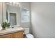 Well-lit half bathroom featuring a sink, toilet, and window at 20626 Willowbend Ln, Parker, CO 80138