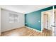 Bright bedroom with wood flooring, accented teal wall, and large window, creating a cozy and modern space at 6110 Habitat Dr # 2, Boulder, CO 80301