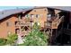 Exterior view of brown building featuring multiple balconies, staircases and mature landscaping at 6110 Habitat Dr # 2, Boulder, CO 80301