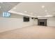Spacious basement with carpeted floors, a painted fireplace and a large mounted television at 785 Fillmore St, Denver, CO 80206