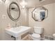 Practical bathroom features a pedestal sink, mirrored vanity and easy-to-clean toilet at 785 Fillmore St, Denver, CO 80206