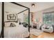 Cozy bedroom with a four-poster bed, workspace and natural light streaming through the windows at 785 Fillmore St, Denver, CO 80206