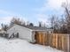 Home's exterior with a fenced yard and a snowy landscape at 3398 Wadsworth Blvd, Wheat Ridge, CO 80033