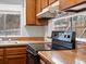 This kitchen includes wooden cabinets, a modern stove, and laminate countertops at 3398 Wadsworth Blvd, Wheat Ridge, CO 80033