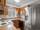 Well-lit kitchen featuring wood cabinets and stainless steel refrigerator at 3398 Wadsworth Blvd, Wheat Ridge, CO 80033
