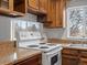 Kitchen featuring wood cabinets, countertops, and a white range at 3398 Wadsworth Blvd, Wheat Ridge, CO 80033