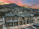 Condo's exterior with stone pillars, balconies, and dark wood against mountain backdrop at sunset at 2152 Bighorn Rd # 103, Georgetown, CO 80444