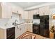 Bright kitchen featuring wood-style floors, black appliances, light wood cabinets, and white countertops at 2152 Bighorn Rd # 103, Georgetown, CO 80444