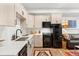 Bright kitchen featuring wood-style floors, black appliances, light wood cabinets, and white countertops at 2152 Bighorn Rd # 103, Georgetown, CO 80444