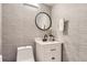 Modern bathroom features sleek vanity, round mirror, and stylish textured wallpaper at 9747 W Cornell Pl, Lakewood, CO 80227