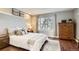 Serene bedroom with a cozy bed, natural light from a large window, and decorative shelving at 9747 W Cornell Pl, Lakewood, CO 80227