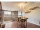 Dining room with wood table set, modern chandelier, and stone accent wall at 9747 W Cornell Pl, Lakewood, CO 80227