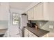 Compact kitchen with stainless steel refrigerator, bright cabinets and countertop space at 9747 W Cornell Pl, Lakewood, CO 80227