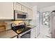 Kitchen featuring stainless steel appliances, a range, and white cabinets at 9747 W Cornell Pl, Lakewood, CO 80227