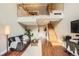 The living room features hardwood floors, a modern sofa, and a staircase to the loft at 9747 W Cornell Pl, Lakewood, CO 80227