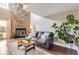 Cozy living room boasting a stone fireplace, comfortable seating, and abundant natural light at 9747 W Cornell Pl, Lakewood, CO 80227