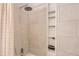 Clean shower area equipped with neutral tiling, a built-in shower caddy, and excellent lighting at 9747 W Cornell Pl, Lakewood, CO 80227