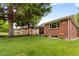 Expansive backyard featuring a lush lawn and mature trees surrounding the charming brick home at 5185 N Meade Street St, Denver, CO 80221