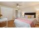 Bedroom featuring wood floors, neutral walls, closet and a bed with pink blanket and decorative pillows at 5185 N Meade Street St, Denver, CO 80221