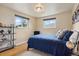 Cozy bedroom with hardwood floors, two windows, and a comfortable bed with a blue comforter and decorative pillows at 5185 N Meade Street St, Denver, CO 80221