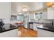 Bright kitchen featuring white cabinets, stainless steel appliances, hardwood floors and contrasting dark countertops at 5185 N Meade Street St, Denver, CO 80221
