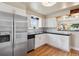 Clean kitchen with white cabinets, stainless steel refrigerator, dark countertop and hardwood floors at 5185 N Meade Street St, Denver, CO 80221